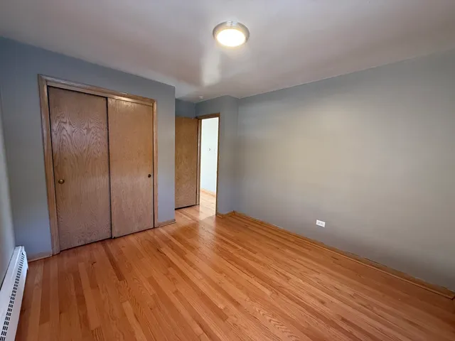 a view of empty room with window and wooden floor