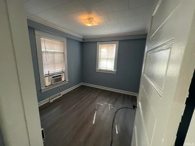 a view of an empty room with wooden floor
