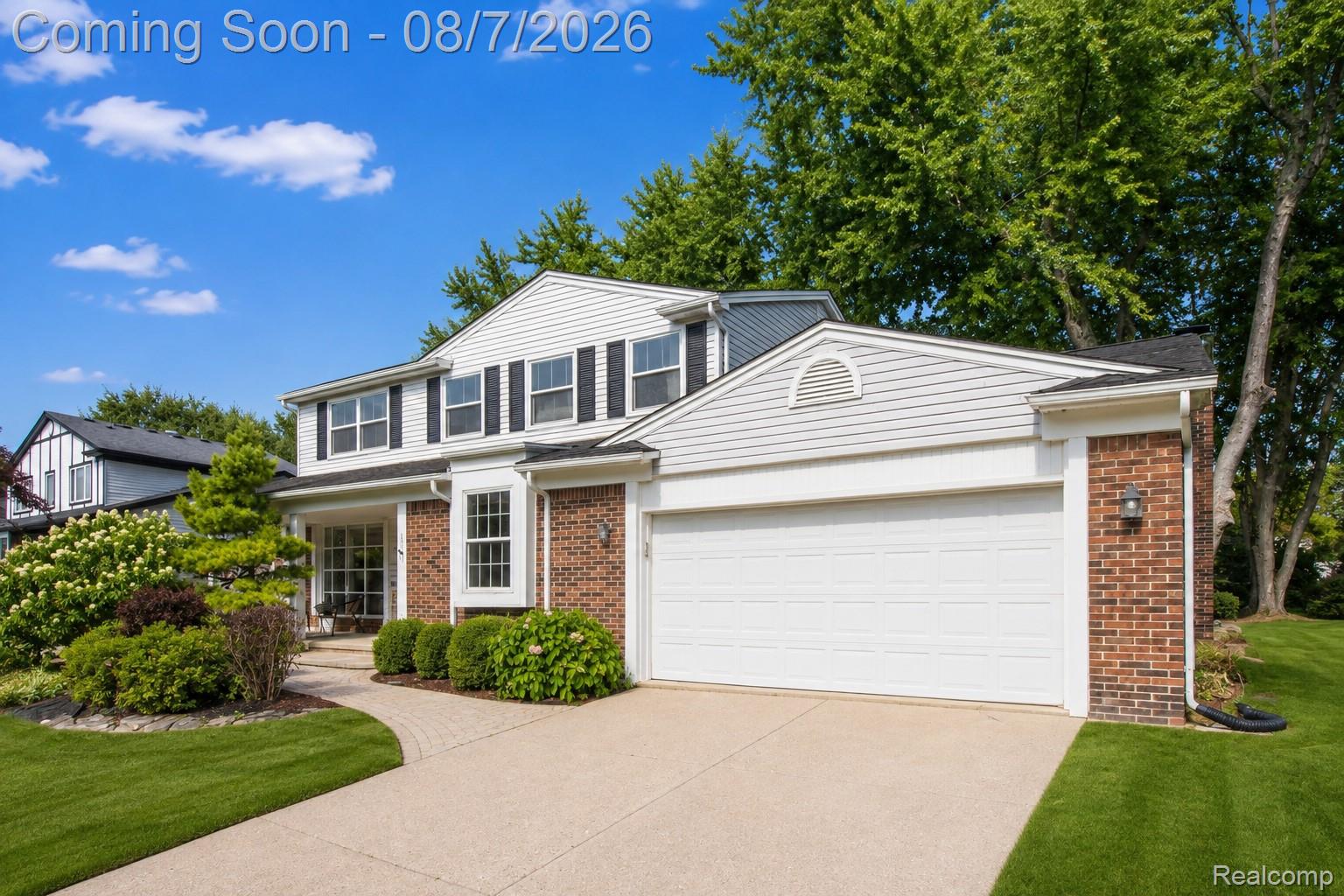 3149 Tamarron Drive Rochester, MI 48309 - Photo 3 of 48 Colonial-style residence featuring a two-car garage, brick facade accents, white siding, and black window shutters