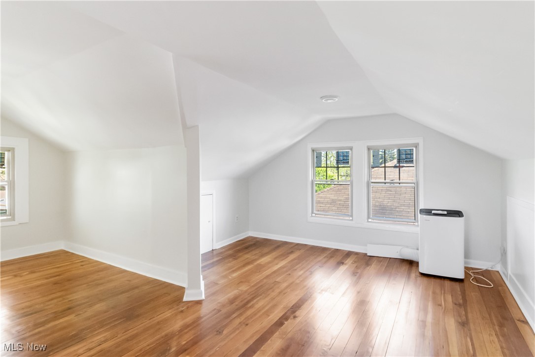 3566 Ludgate Road Cleveland, OH 44120 - Photo 16 of 27 Additional living space featuring hardwood / wood-style floors, vaulted ceiling, plenty of natural light, and baseboards