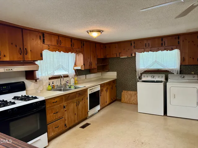 a kitchen with a stove top oven sink and cabinets
