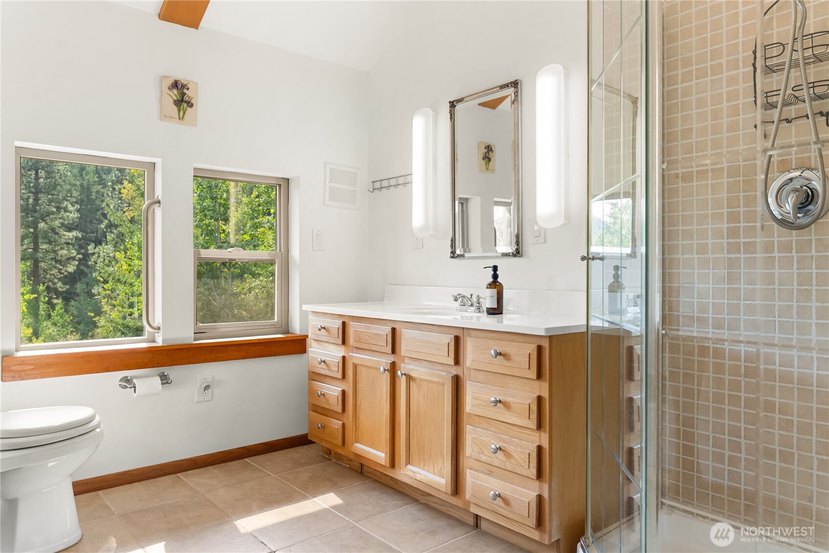 96 Alder Creek Road Twisp, WA 98856 - Photo 23 of 40 a bathroom with a double vanity sink a mirror and a bathtub next to a window