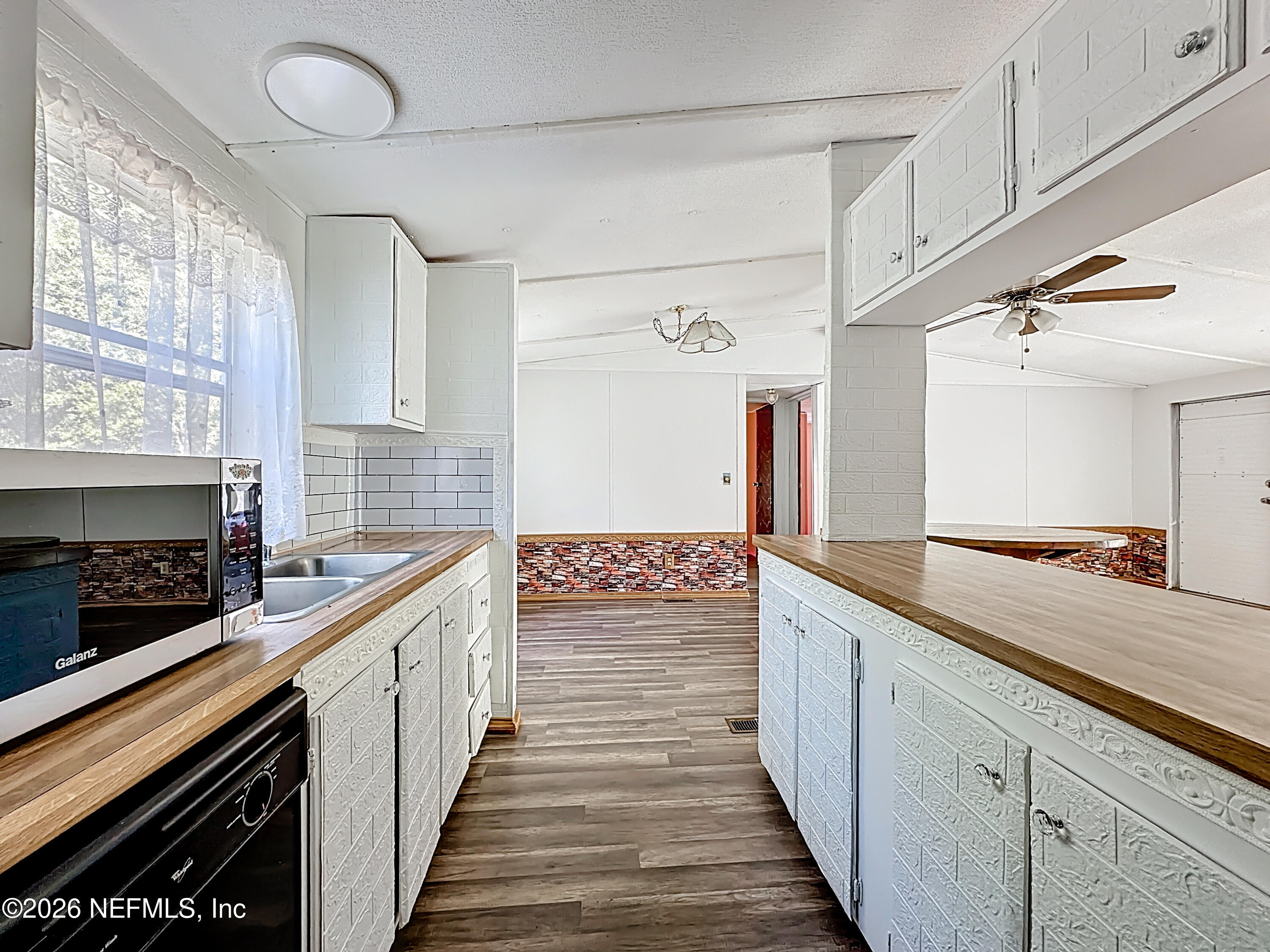 133 Reaves Avenue Interlachen, FL 32148 - Photo 17 of 38 a kitchen with stainless steel appliances a sink and cabinets