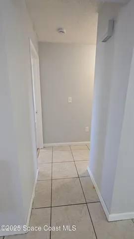 a view of an empty room with window chandelier fan