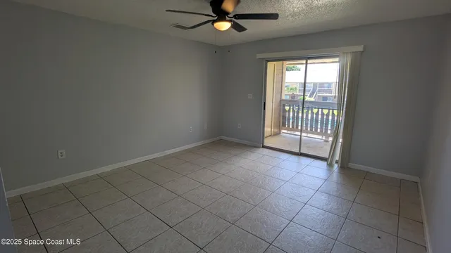 an empty room with windows and ceiling fan