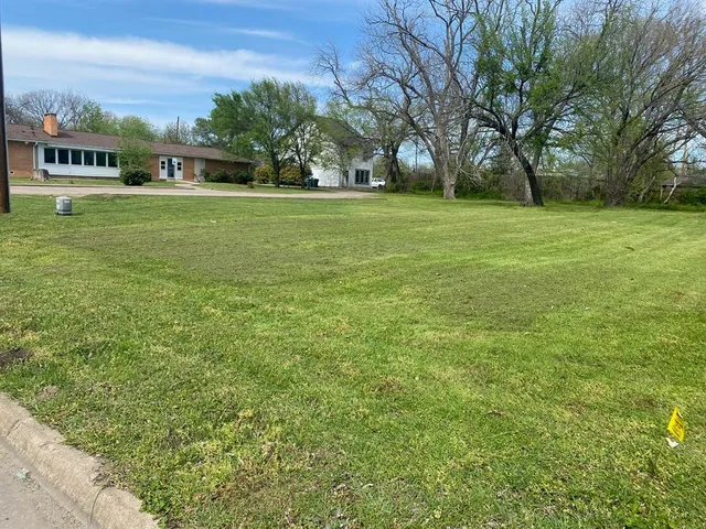 a grassy field with trees in the background