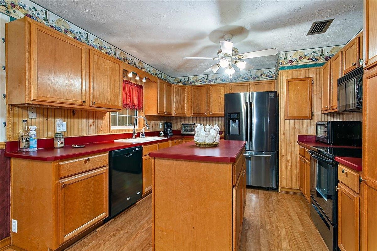 3351 Pacetti Road St. Augustine, FL 32092 - Photo 7 of 24 a kitchen with stainless steel appliances granite countertop a refrigerator a sink dishwasher a stove and a dining table with wooden floor
