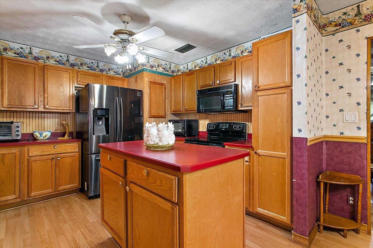 3351 Pacetti Road St. Augustine, FL 32092 - Photo 8 of 24 a kitchen with stainless steel appliances granite countertop a refrigerator a stove top oven a sink dishwasher and wooden cabinets