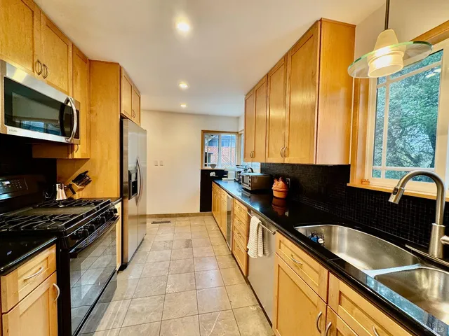 a kitchen with stainless steel appliances a sink a stove and a microwave