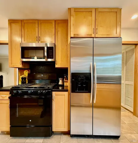 a kitchen with granite countertop cabinets and steel stainless steel appliances with wooden floor