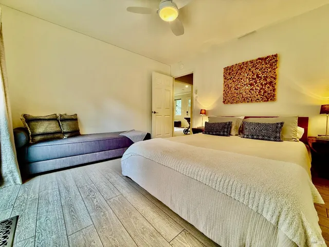 a bedroom with a bed and wooden floor