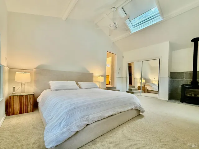 a spacious bedroom with a bed a couch and a chandelier