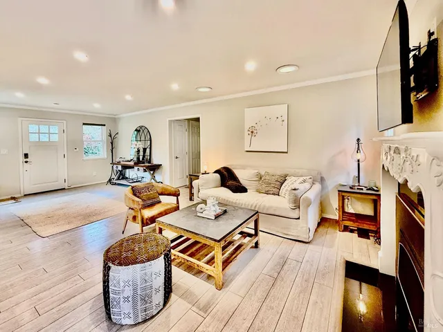 a living room with furniture a flat screen tv and a fireplace