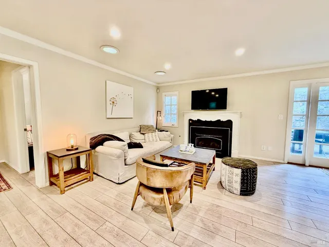a living room with furniture a flat screen tv and a fireplace