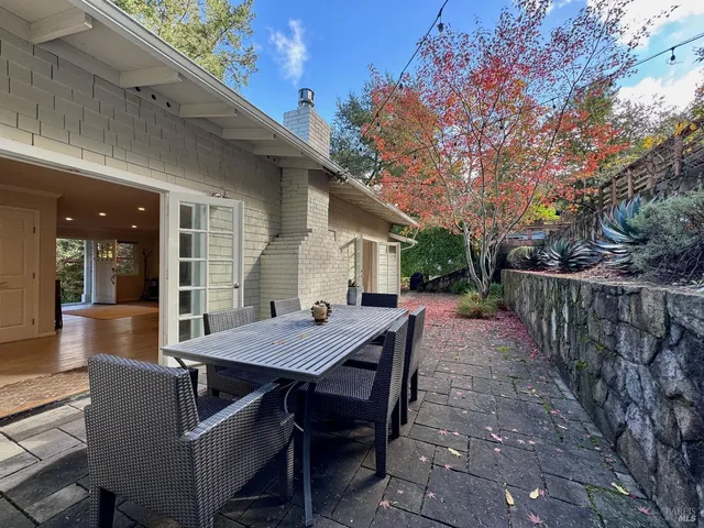 a view of a patio with table and chairs with wooden fence and floor