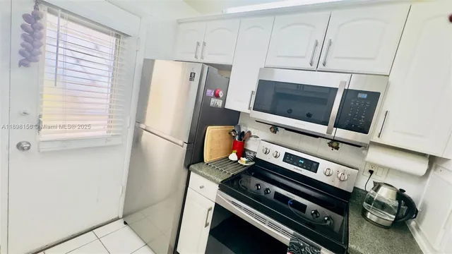 a kitchen with a refrigerator and a stove top oven