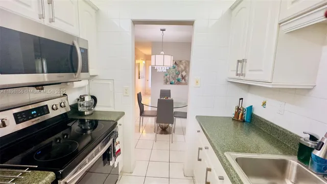 a kitchen with a stove a microwave and cabinets