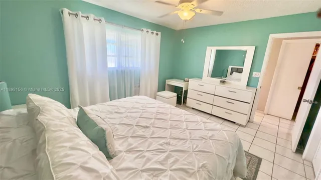 a bedroom with a bed mirror and a hardwood