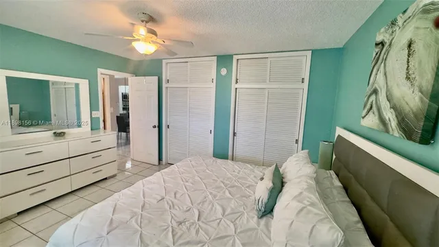 a bedroom with a bed and a painting on the wall