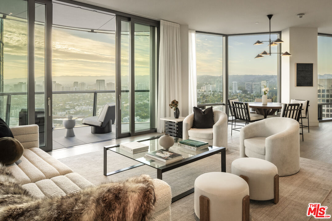 a living room with furniture and floor to ceiling windows