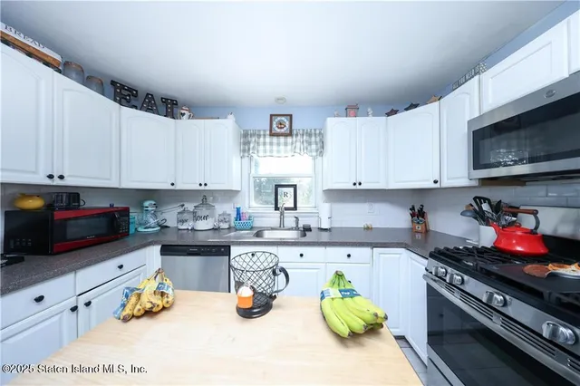 a kitchen with stainless steel appliances granite countertop a stove top oven a sink dishwasher and cabinets with wooden floor