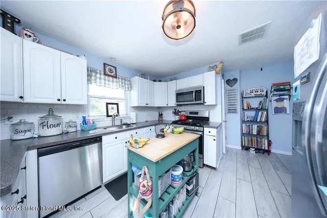 a view of a kitchen with fridge and wooden floor