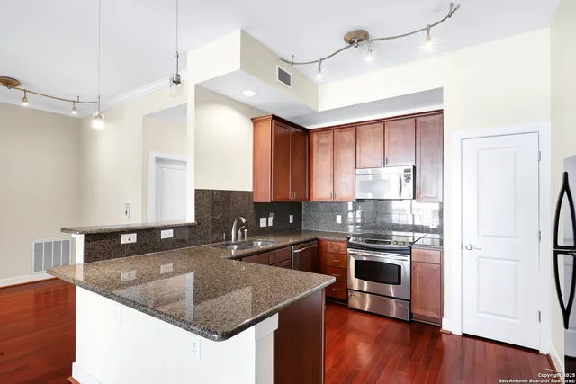 a kitchen with stainless steel appliances granite countertop a sink stove and refrigerator