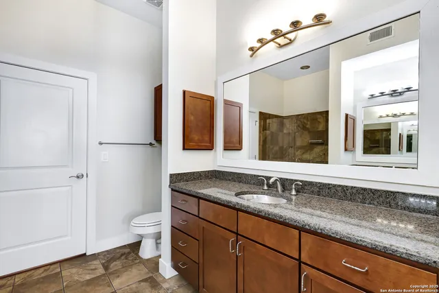 a bathroom with a granite countertop sink and a mirror
