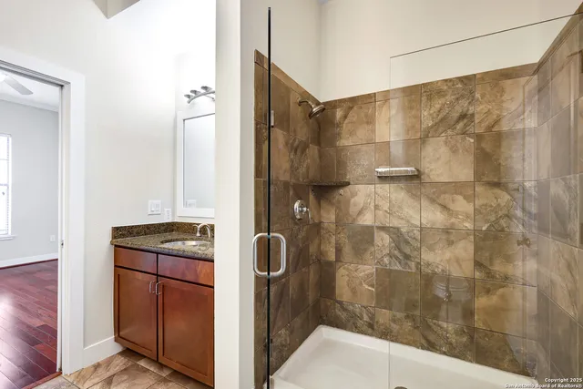 a bathroom with a granite countertop shower a sink and a stove