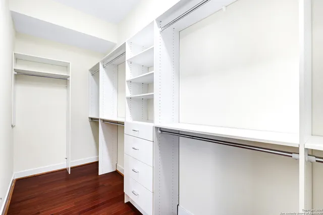 a view of closet with wooden floor