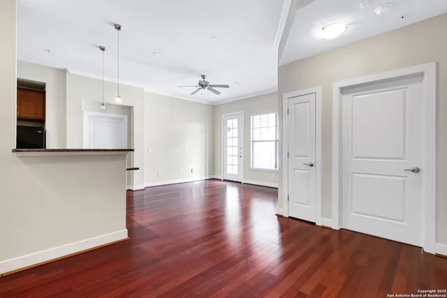 an empty room with wooden floor and windows