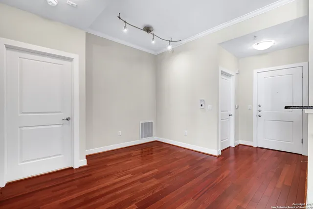 a view of an empty room with wooden floor