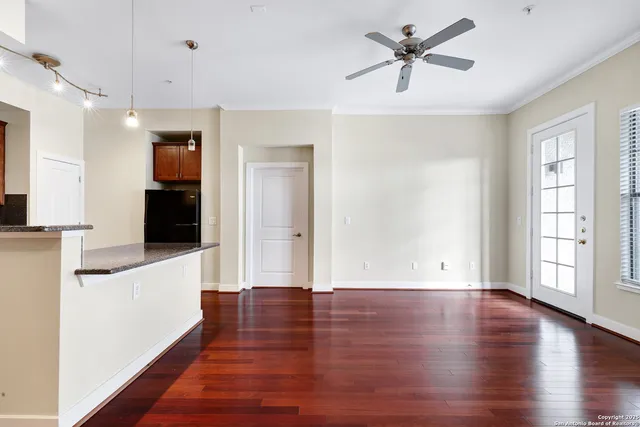 a view of a livingroom with wooden floor and a ceiling fan