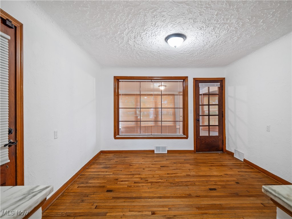 3605 Center Road Avon, OH 44011 - Photo 14 of 34 Empty room with wood-type flooring and a textured ceiling