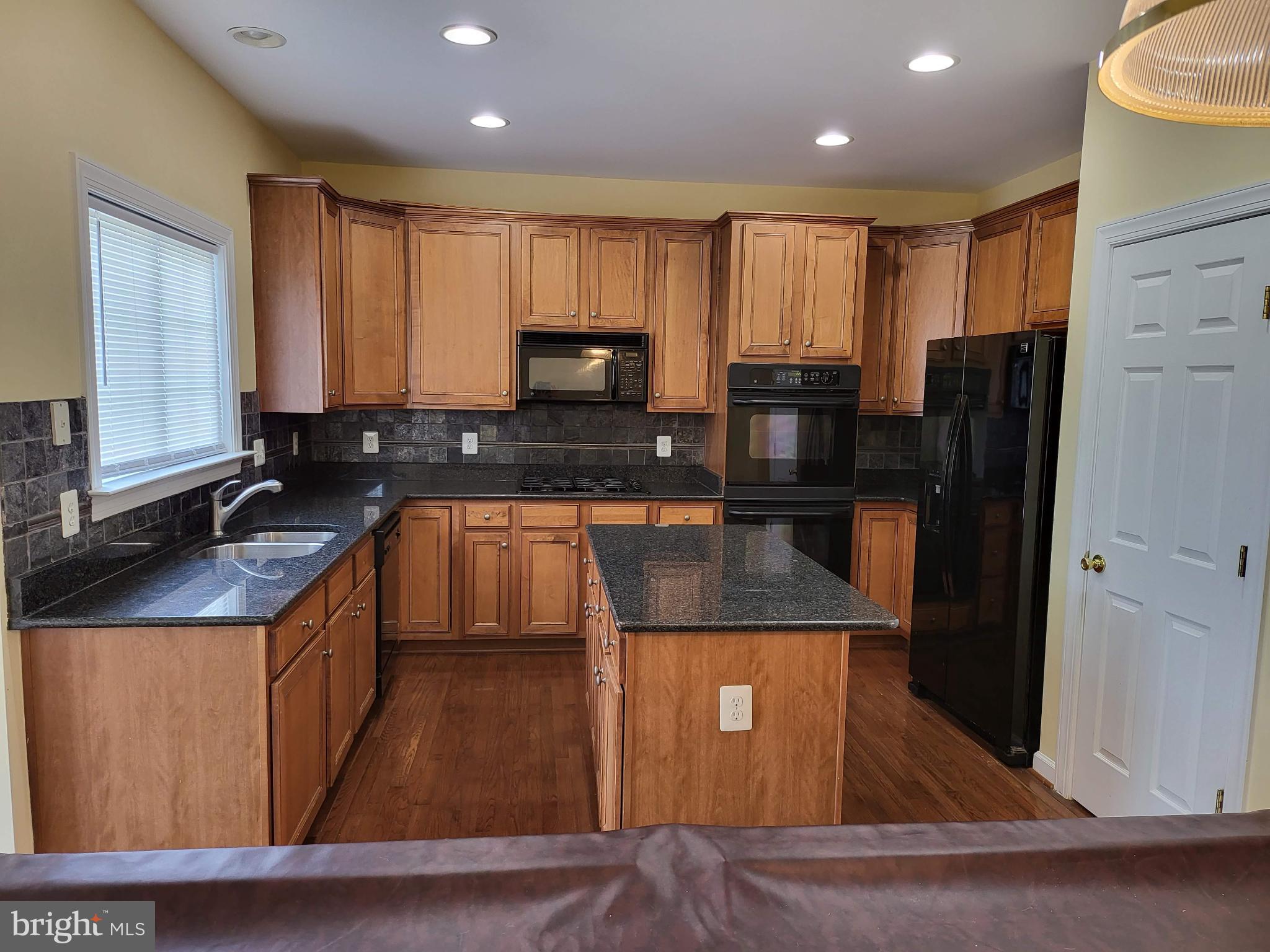 6161 Popes Creek Place Haymarket, VA 20169 - Photo 3 of 23 a kitchen with kitchen island granite countertop a refrigerator stove and sink