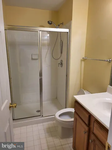 a bathroom with a granite countertop shower and a toilet