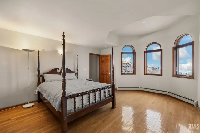 a spacious bedroom with a bed and a flat screen tv