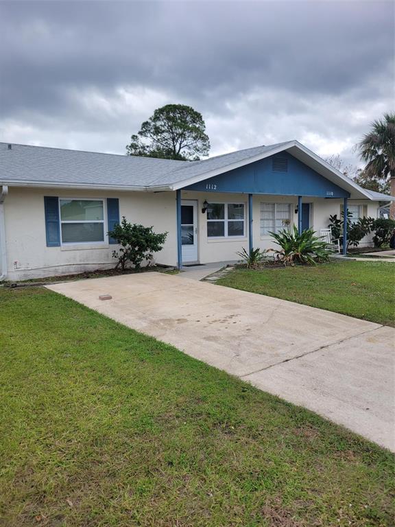 a view of a yard in front of a house with large trees