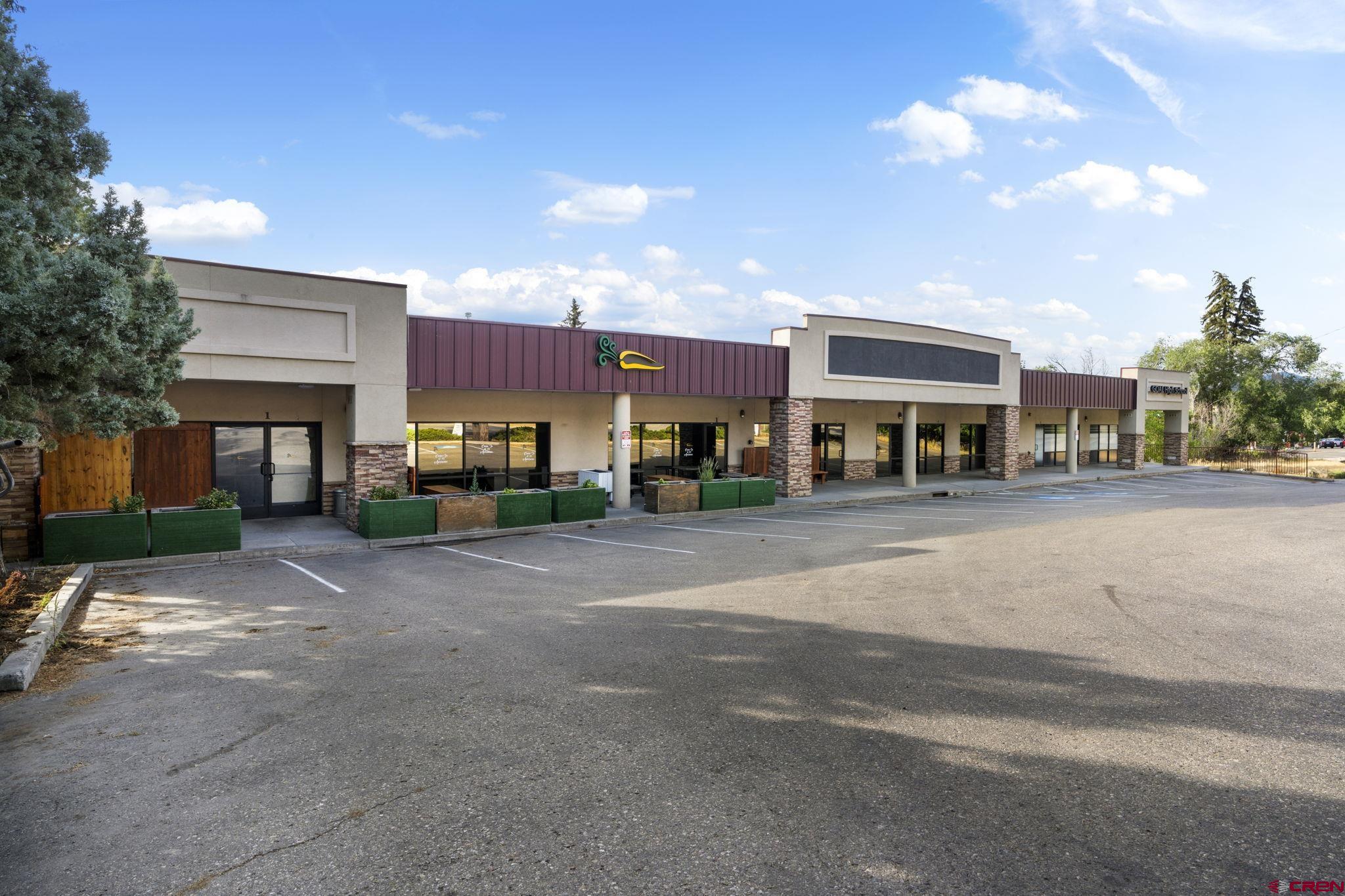a city street lined with buildings and a cars parked on the side of road