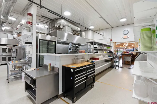 a kitchen with stainless steel appliances kitchen island granite countertop a stove and a refrigerator