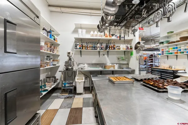 a hallway with lots of clutter and stainless steel appliances