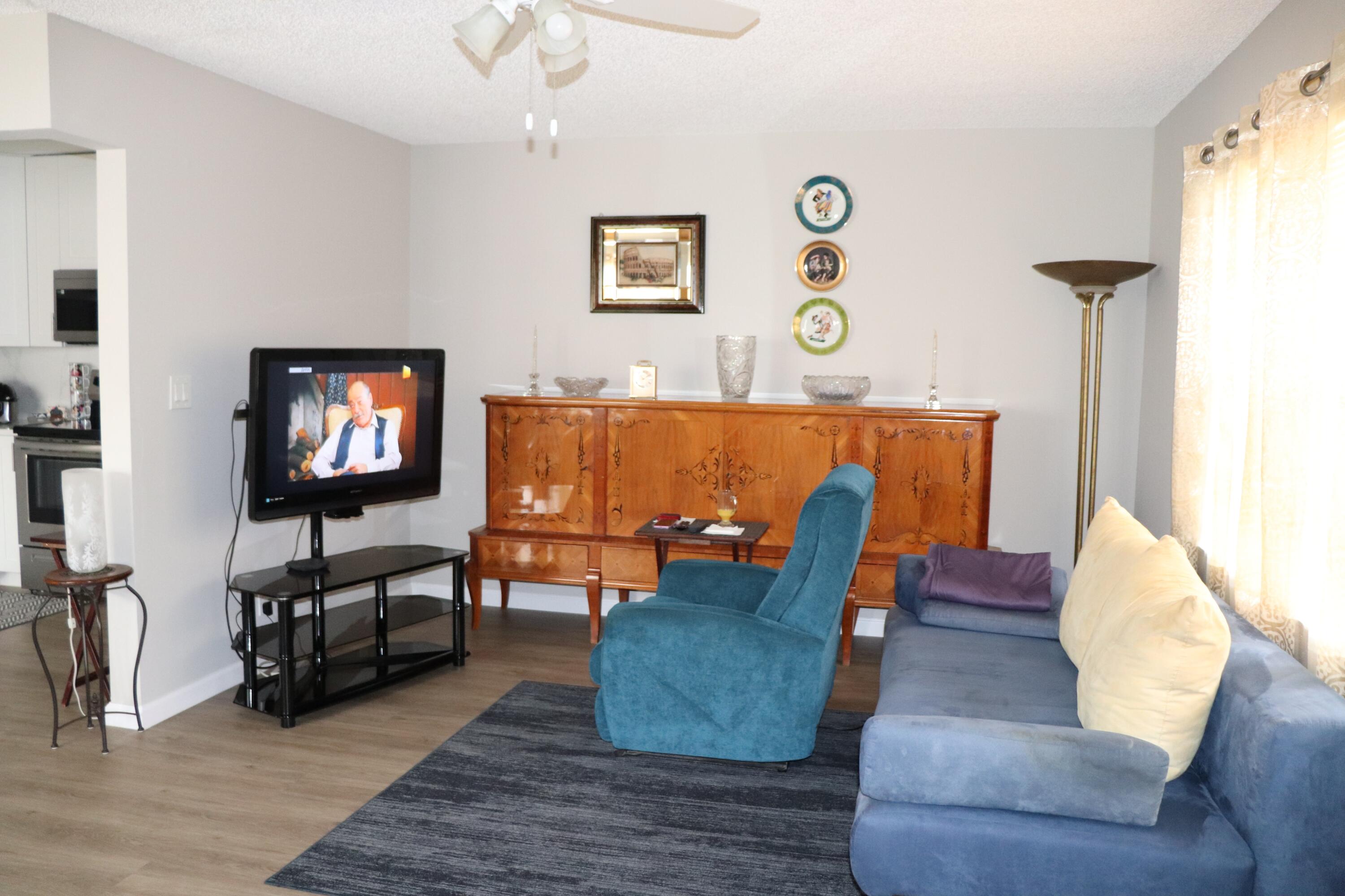 801 Flanders South, Unit Q Delray Beach, FL 33484 - Photo 2 of 15 a living room with furniture and a flat screen tv