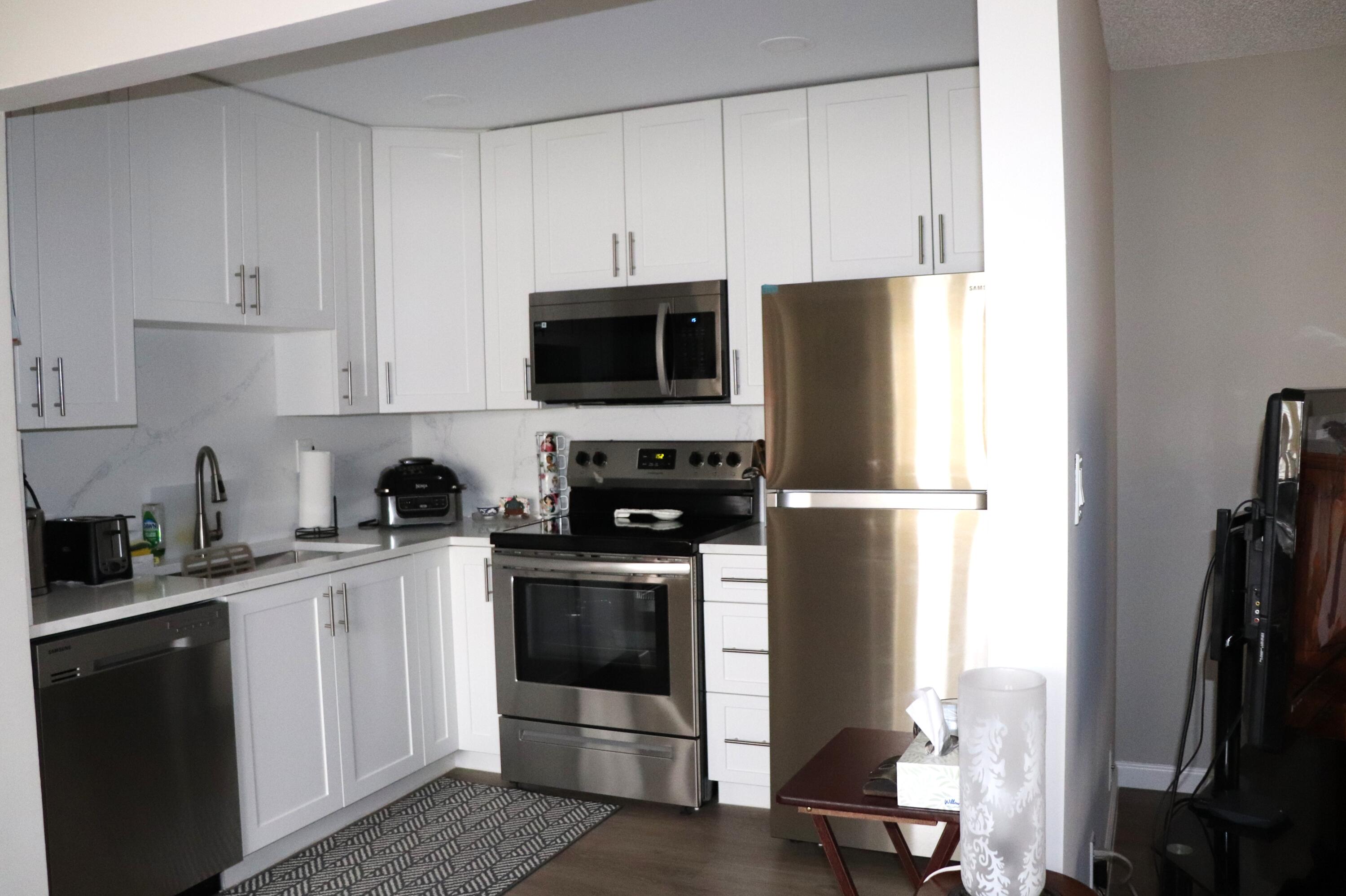 801 Flanders South, Unit Q Delray Beach, FL 33484 - Photo 5 of 15 a kitchen with a sink appliances and cabinets