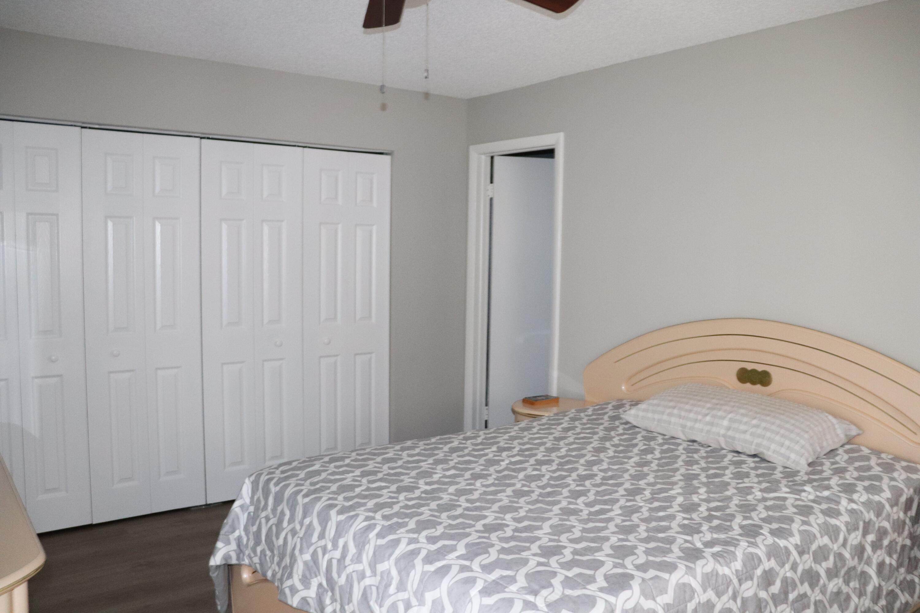 801 Flanders South, Unit Q Delray Beach, FL 33484 - Photo 8 of 15 a bedroom with a bed and a gate