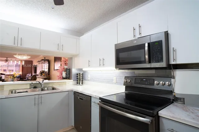 a kitchen with a sink stainless steel appliances and cabinets