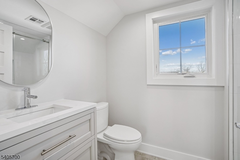 8 Willow Street Millburn, NJ 07041 - Photo 25 of 45 a bathroom with a toilet a sink and mirror