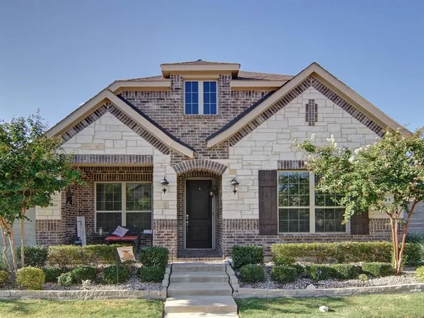 a front view of a house with a yard and potted plants