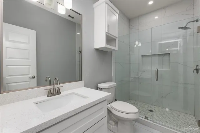 a white toilet sitting next to a bathroom sink