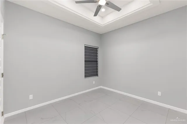 an empty room with a ceiling fan and window