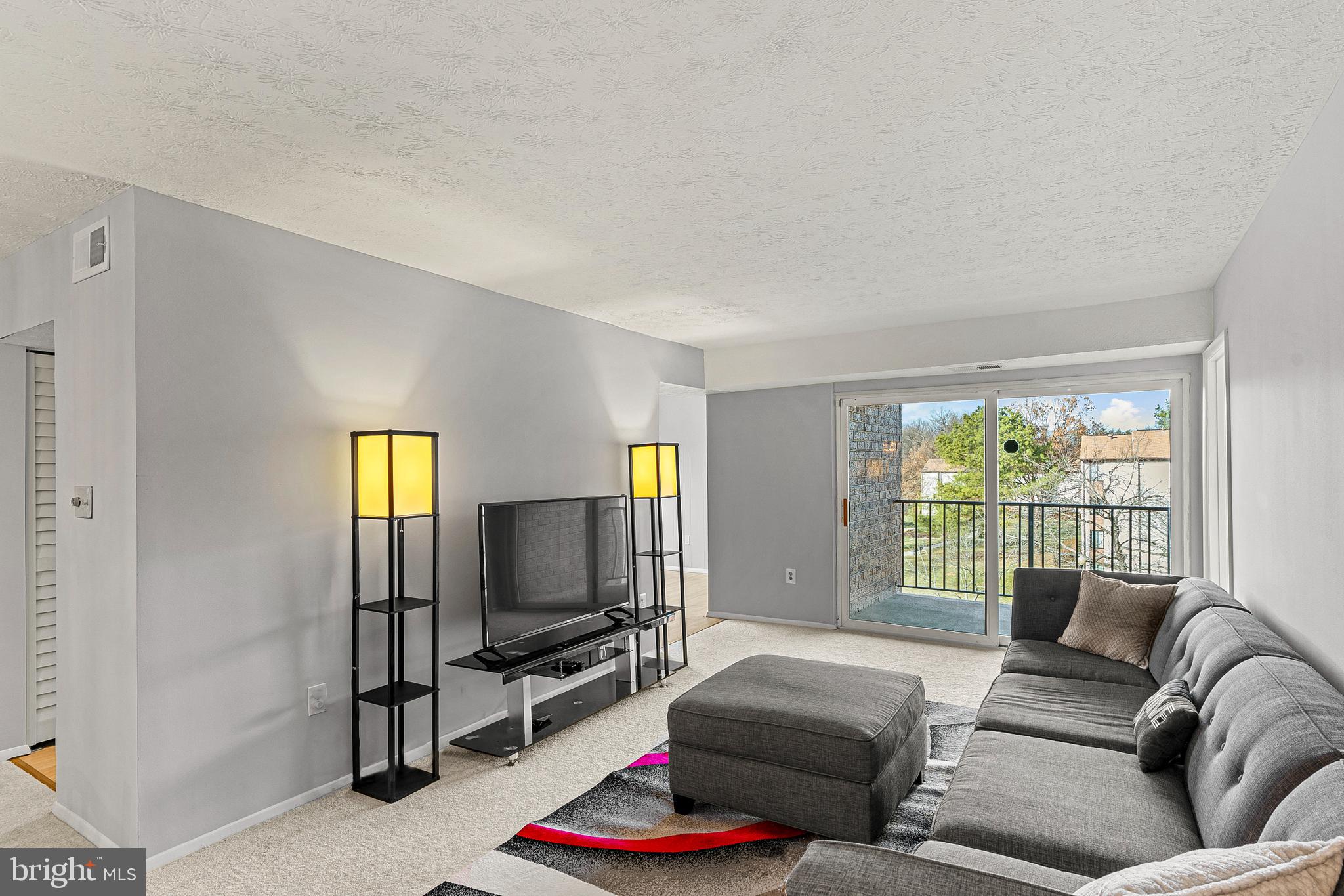 8005 Mandan Road, Unit 302 Greenbelt, MD 20770 - Photo 5 of 22 a living room with furniture and a flat screen tv
